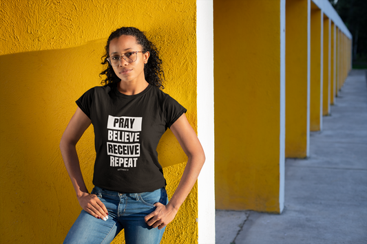 Woman wearing Christian T-shirt: Pray, Believe, Receive, Repeat